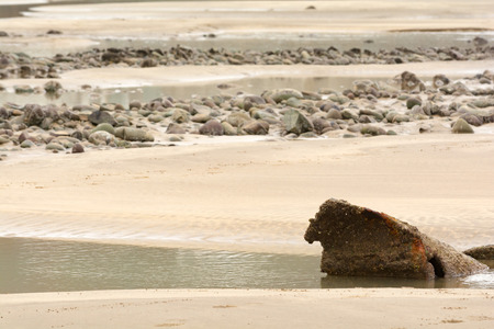 Sandy UK beach at low tide with rock poolsの写真素材