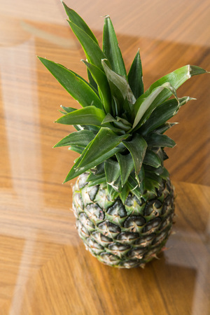 Fresh tasty pineapple on natural wooden backgroundの写真素材
