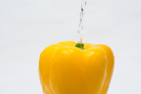 Whole fresh yellow pepper vegetable isolated on whiteの写真素材