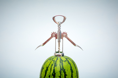 Watermelon being opened by a bottle opener for a fresh tasteの写真素材