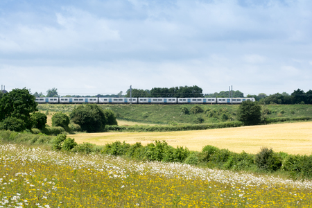 Train on the railway travelling through rural countrysideの写真素材