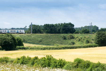 Train on the railway travelling through rural countrysideの写真素材