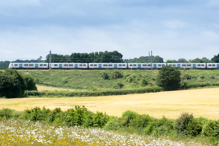 Train on the railway travelling through rural countrysideの写真素材