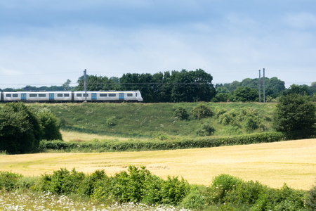 Train on the railway travelling through rural countrysideの写真素材