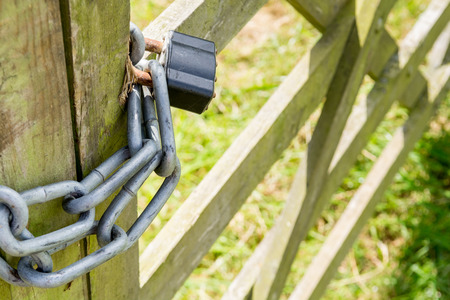 Gate locked with a  metal chain and padlockの写真素材