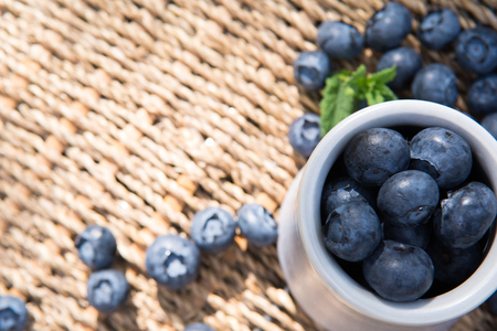 Blueberries. Freshly picked blueberry in ceramic bowl with berries and natural background. Blueberries are known to contain anitoxidant for nutrition health benefitsの写真素材