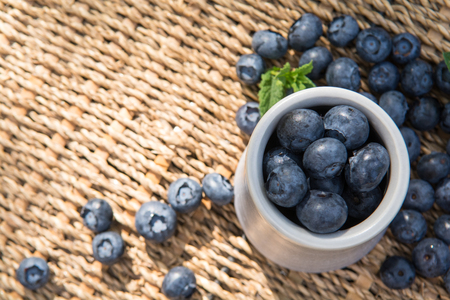 Blueberries. Freshly picked blueberry in ceramic bowl with berries and natural background. Blueberries are known to contain anitoxidant for nutrition health benefitsの写真素材
