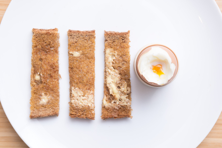 Soft boiled eggs with toast on a white plate. Breakfastの写真素材