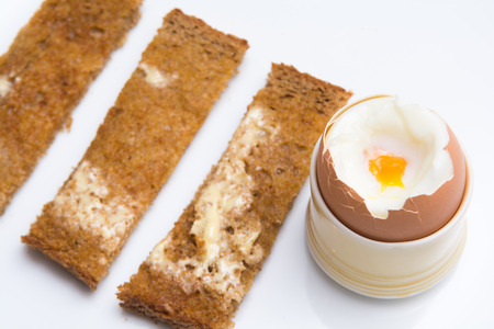 Soft boiled eggs with toast on a white plate. Breakfastの写真素材
