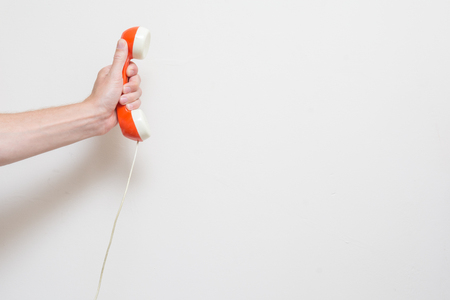 Hand holding a retro style telephone receiverの写真素材