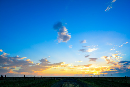 Road leading to horizon over sunset landscapeの写真素材