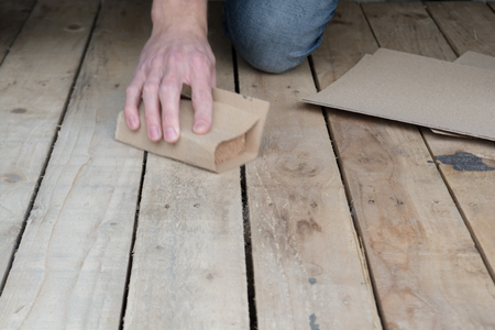 Man working with sand paper in carpentry tradeの写真素材