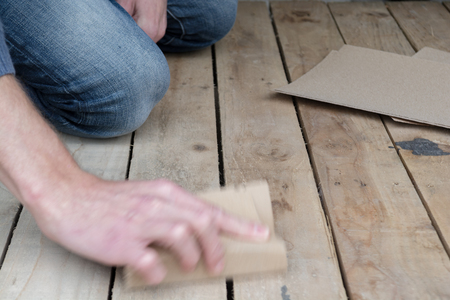 Man working with sand paper in carpentry tradeの写真素材
