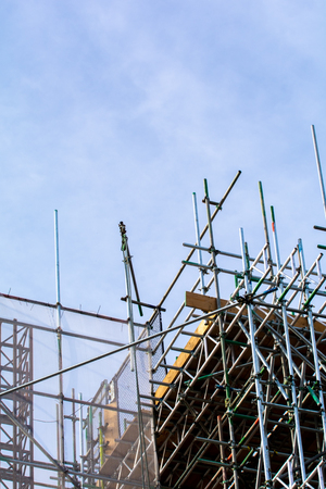 Scaffolding on exterior of building at construction siteの写真素材