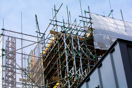 Scaffolding on exterior of building at construction siteの写真素材