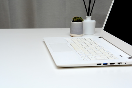 Laptop computer on modern office desk with blank screenの写真素材