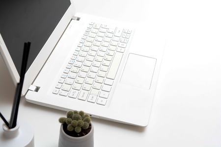 Laptop computer on modern office desk with blank screenの写真素材