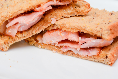 Freshly made bacon sandwich on a white plateの写真素材