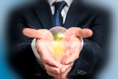 New business idea concept of business man holding glowing light bulbの写真素材