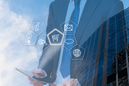 Business vision and planning. Man holds tablet with business iconsの写真素材