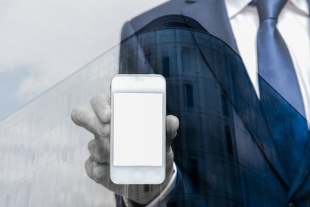 Business man in suit holds a smart phone with blank white screenの写真素材