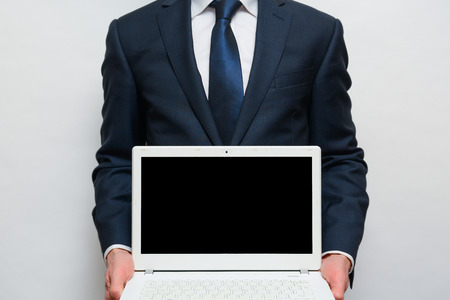 Laptop with blank screen, man is holding screen facing cameraの写真素材