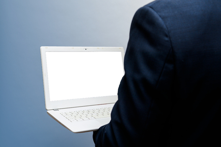 Man using laptop with blank white screen, shot from over shoulderの写真素材