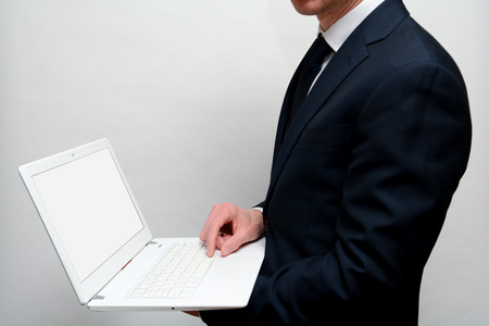 Man using laptop with blank white screen, shot from over shoulderの写真素材