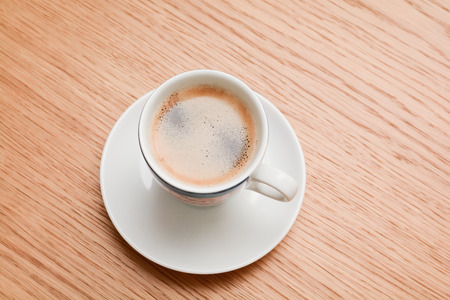 Espresso in a white cup on wooden tableの写真素材