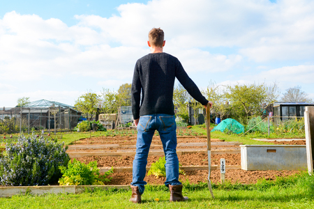 Male gardener at allotment with work toolsの写真素材