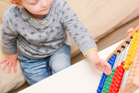 Child learning to count. Young boy using an abacus to learn mathsの写真素材