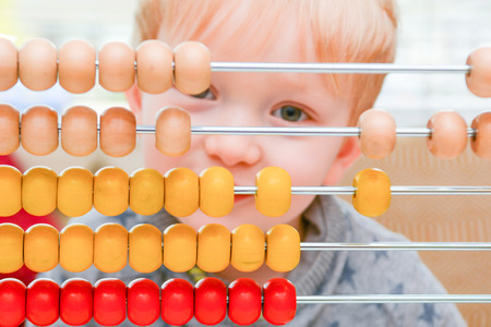 Child learning to count. Young boy using an abacus to learn maths