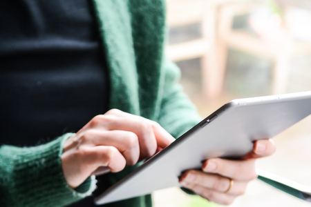 Woman using an tablet device at home with blurred background