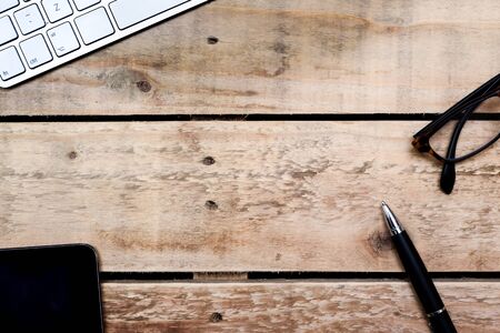 Modern office overhead view of desk and creative work place objects on wooden tableの写真素材