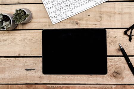 Modern office overhead view of desk and creative work place objects on wooden tableの写真素材