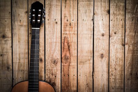 Acoustic guitar on vintage style wood background. Copy space with musical guitar instrumentの写真素材