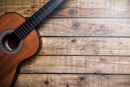 Acoustic guitar on vintage style wood background. Copy space with musical guitar instrument