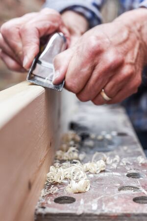 Close up of male hands doing woodwork using tools