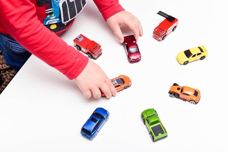 Playing at home The boy is playing with toy cars at the tableの写真素材