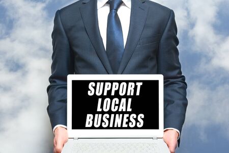 local business support man holding sign on laptop to promote small local businessの写真素材