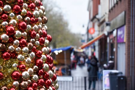 Christmas shopping a view of a high street with shops and retail christmas market in the backgroundの写真素材