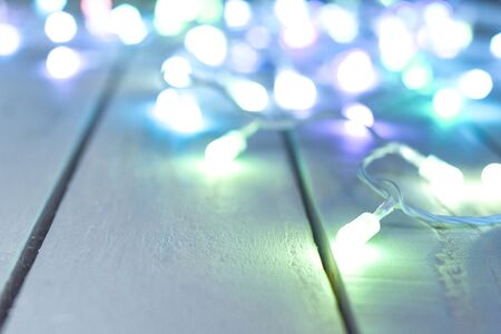 Bright lights blur into the background over a white vintage style wooden tableの写真素材