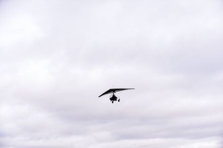 Person flying away into the horizon on a small aircraft single seat microlight as a hobby or sport...