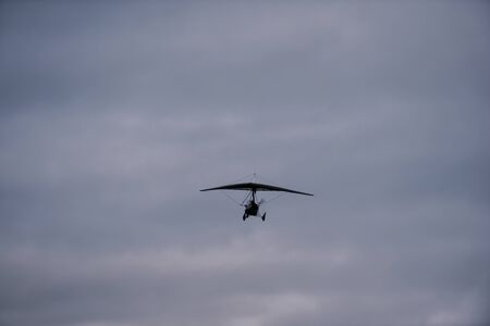 Person flying away into the horizon on a small aircraft single seat microlight as a hobby or sport...
