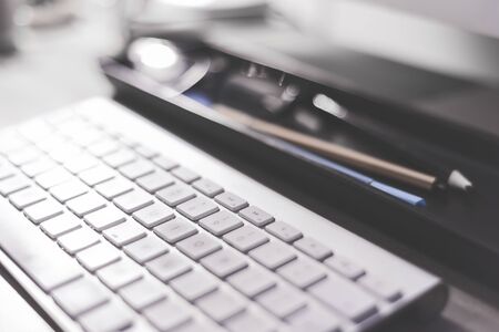 Modern office desk workspace with close up on computer keyboardの写真素材