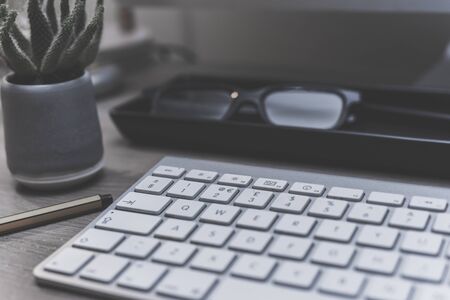Modern office desk  with computer keyboard and office objects on wooden desk, office interior with focus on workingの写真素材