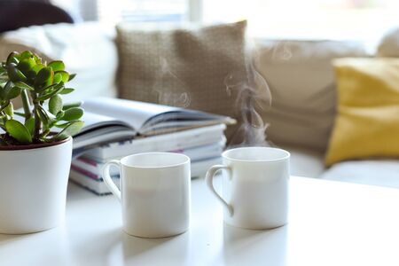 Relaxing sofa area with coffee table and hot drink in modern home interiorの写真素材