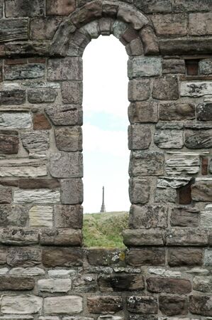 Architectural detail of stone arch in an ancient ruin with a view of tower