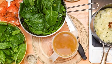 Making soup, an overhead view of food ingredients cooking and being prepared in a home kitchen