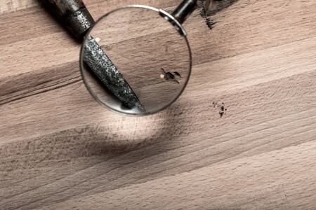 Looking through a magnifying glass at a knife for crime scene cluesの写真素材
